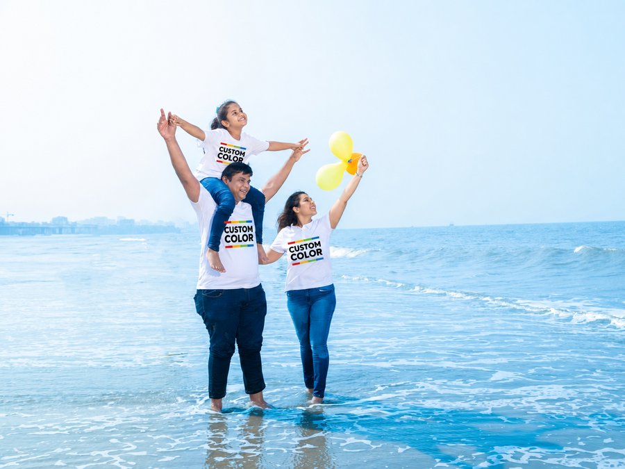 Family of three in matching white tees at the ocean